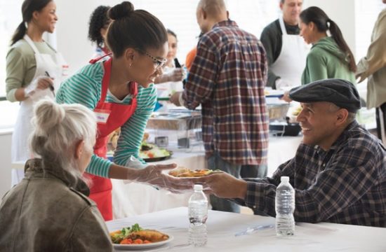 A woman giving a man a plate of food
