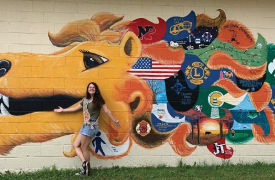 A woman standing by a mural