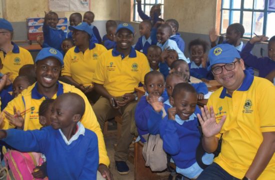Lions and Johnson & Johnson Vision team members spend time with children at a vision screening in Kenya.