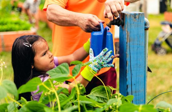 Girl gets water from outdoor pump