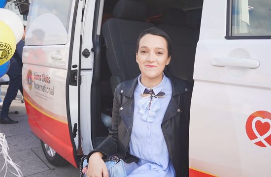 Woman sits in van.