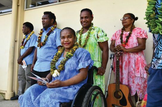 Clerence (pictured seated) smiles at the clinic’s inauguration ceremony.