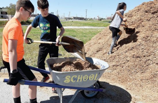 Carl Junction Leos Alex Brownstein, Jackson Hinderliter, and Madeleine Garoutte work on a landscaping project at Irving Elementary School in Joplin, Missouri. Photo by Laurie Sisk/Joplin Globe.