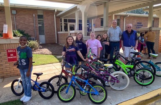 Kids smile in front of new bikes