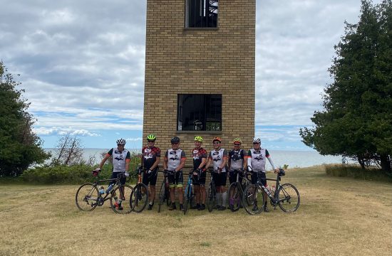 Bikers standing in front of light house