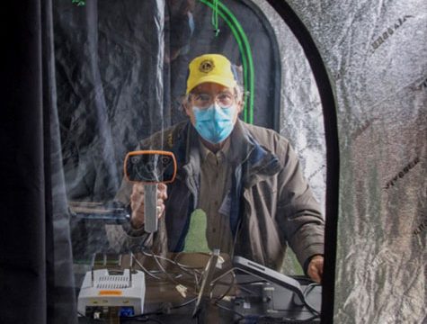 Man in Lions Club hat looks through tent window