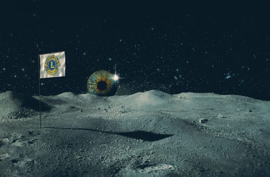 Eye seen rising over the moon next to Lions Clubs flag