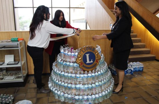 Group of young women making sculpture out of water bottles.