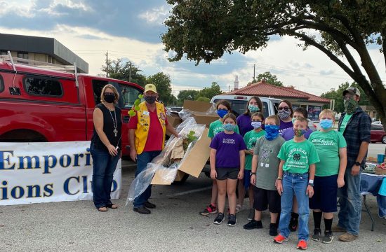 Lions work with 4-H members to plant redbuds.