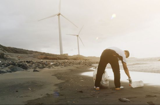 man picking up trash on a beach